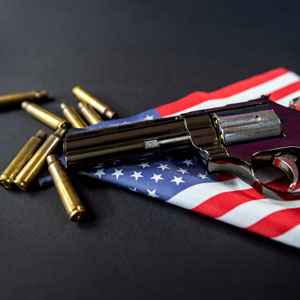 Handgun and bullets on an American flag, symbolizing Weapons Offense - Law Offices Of Robert Keating, PLLC
